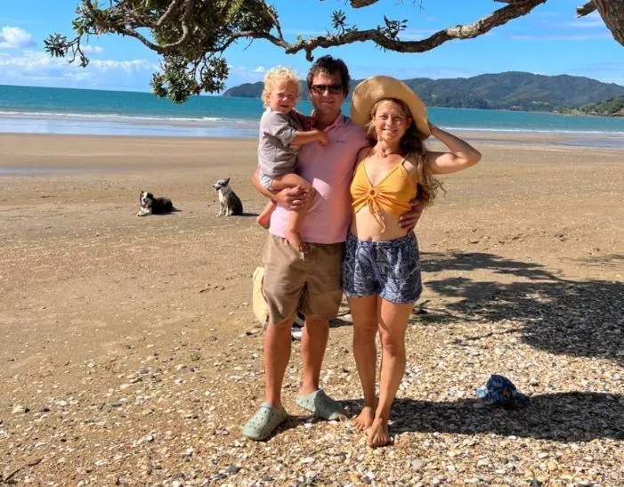 Anastasia and Dan with their little one and two dogs on a Far North beach